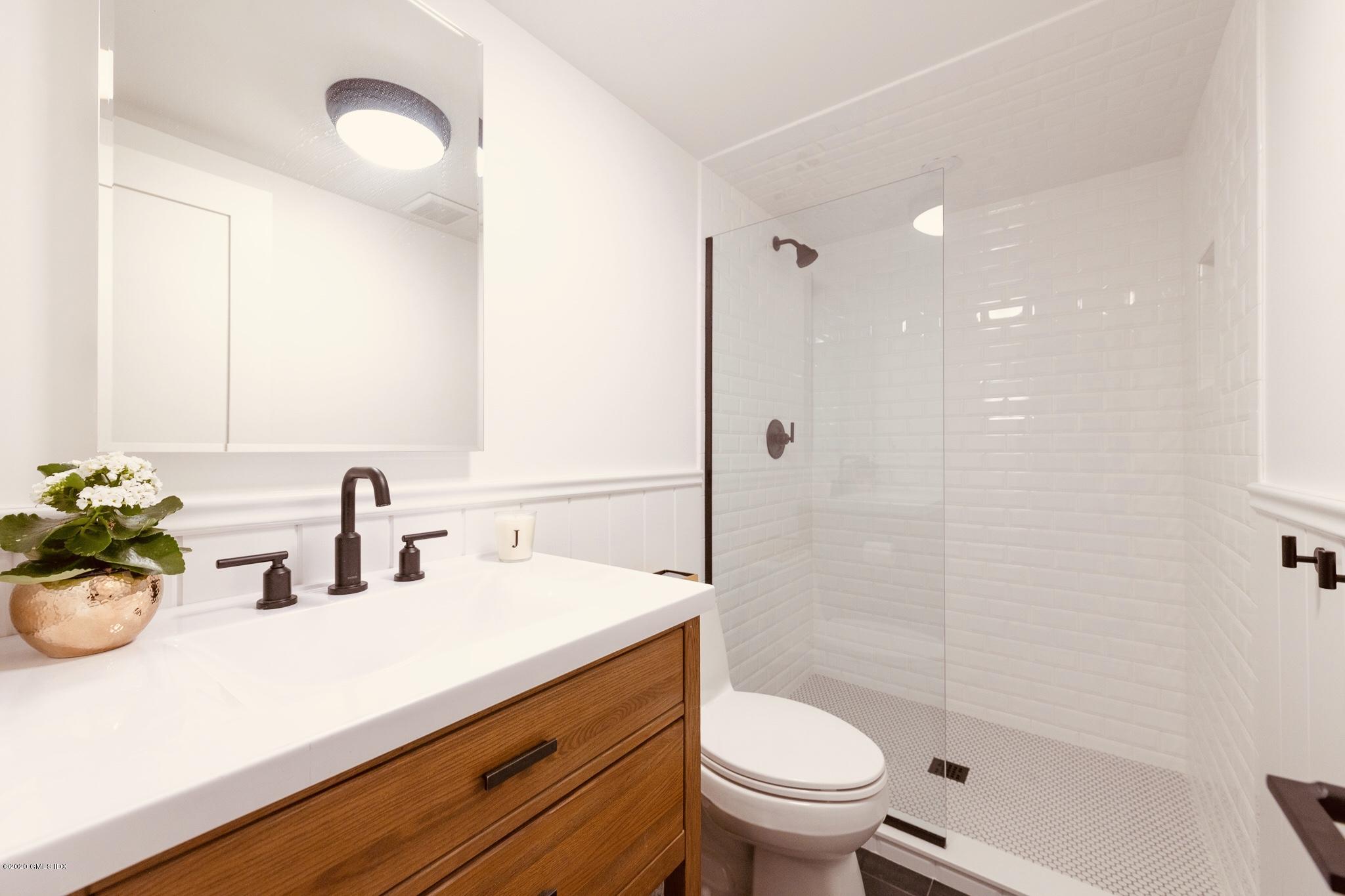 4 Cedar Hill Greenwich, CT 06830 - Photo 23 of 28 a bathroom with a sink a toilet a mirror and shower