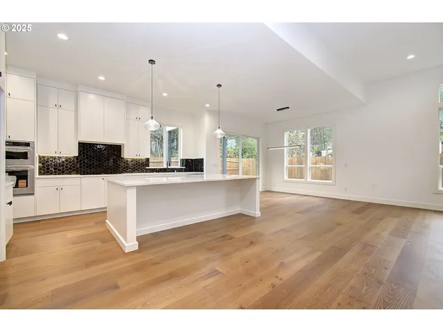 a view of a kitchen with kitchen island and stainless steel appliances