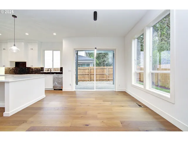 a kitchen with granite countertop a stove a sink a refrigerator a window and a dining table