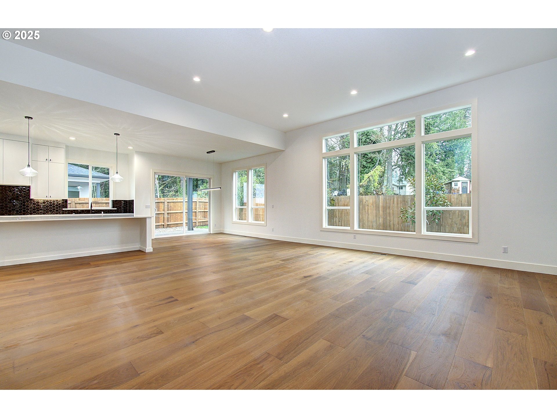 2010 Northeast 159th Street Ridgefield, WA 98642 - Photo 9 of 42 a view of an empty room with wooden floor and a kitchen