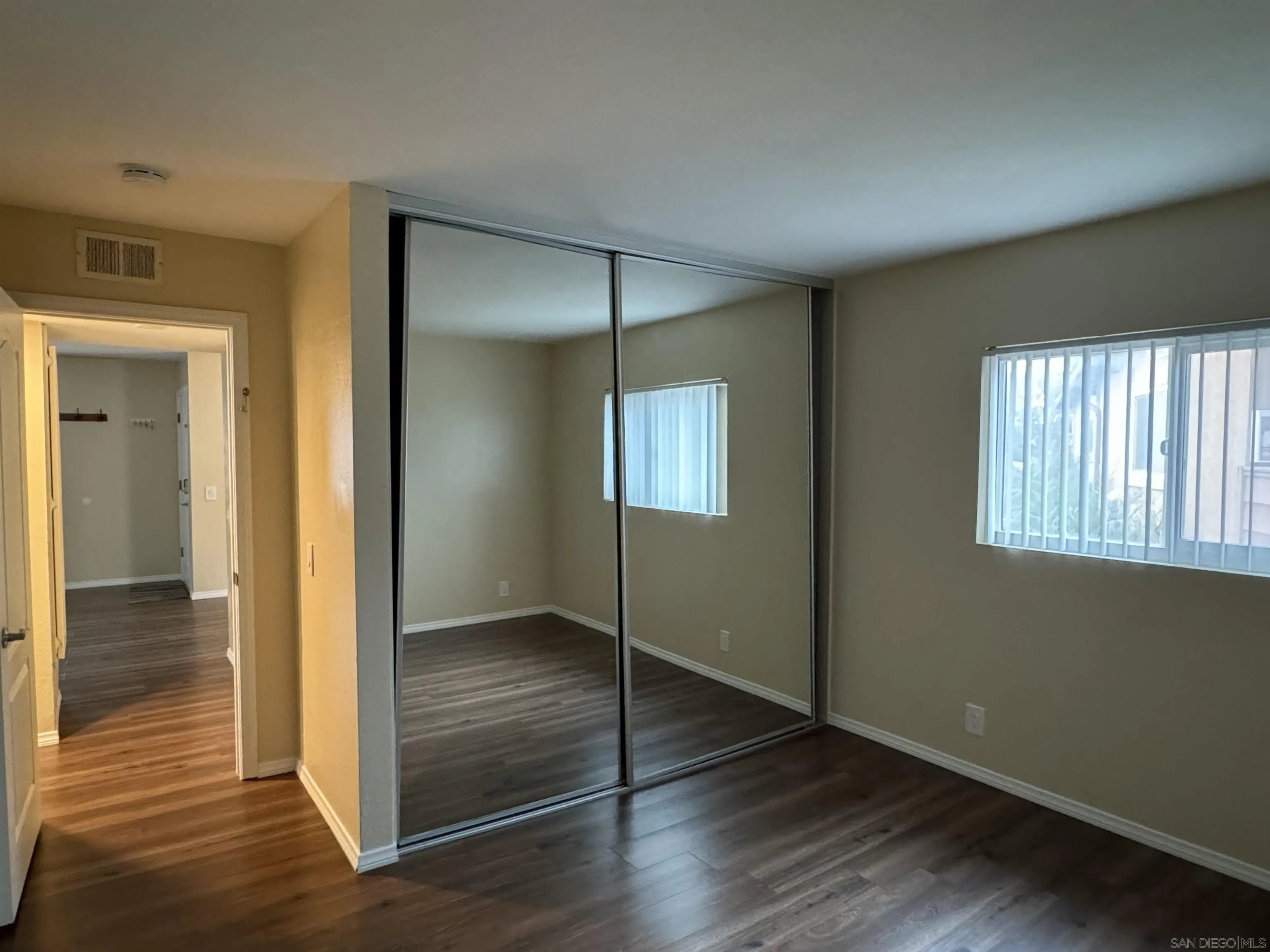 506 Calle Montecito, Unit 40 Oceanside, CA 92057 - Photo 4 of 19 an empty room with wooden floor mirror and windows