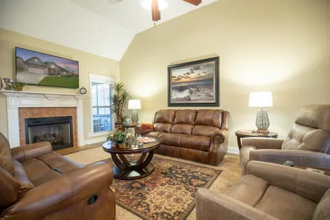 a living room with furniture a flat screen tv and a fireplace