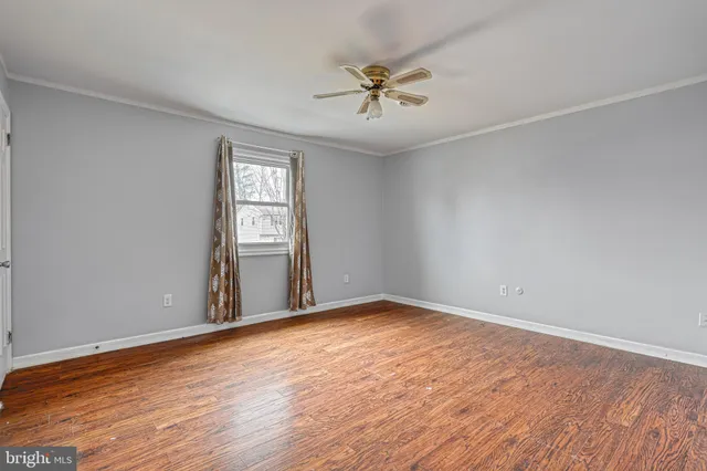 a view of a hallway with wooden floor and stair