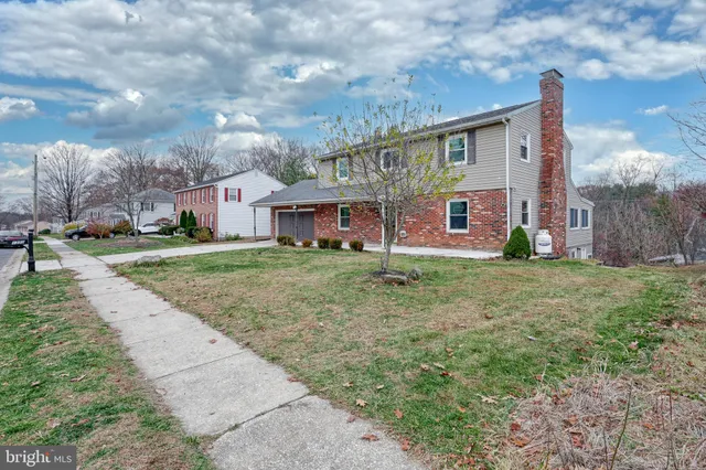 a view of large house with a big yard and large trees