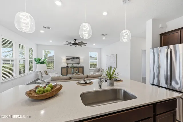 a living room with couches a coffee table and chairs with wooden floor