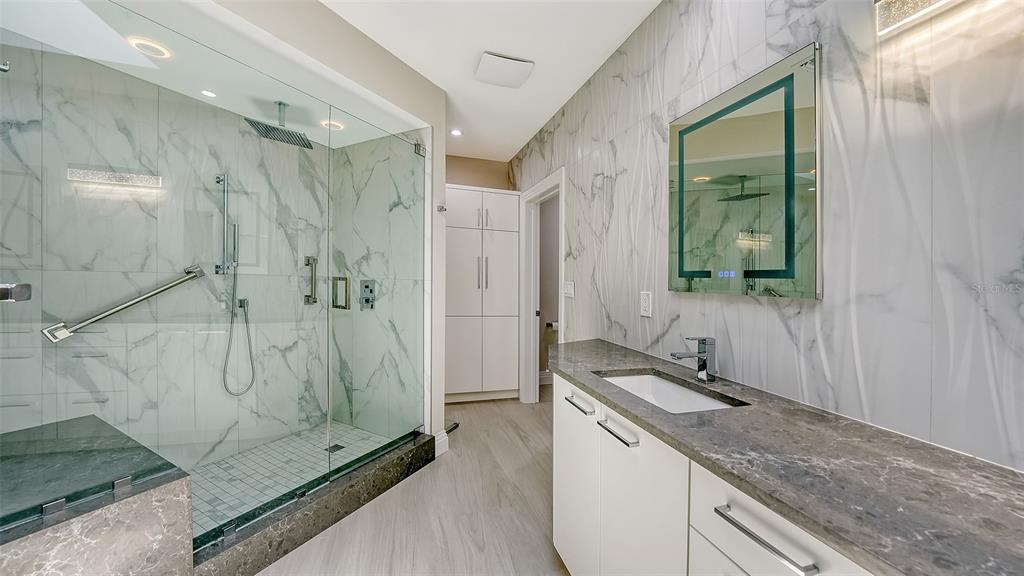535 Sanctuary Drive, Unit C807 Longboat Key, FL 34228 - Photo 34 of 56 a bathroom with a granite countertop sink a mirror and shower
