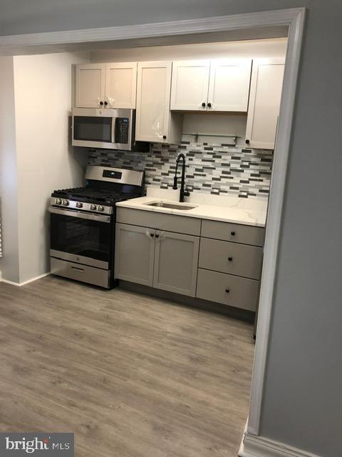 2802 Windsor Avenue Baltimore, MD 21216 - Photo 11 of 37 a kitchen with stainless steel appliances a stove a sink and a microwave