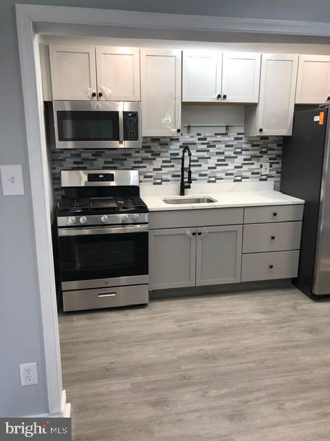 2802 Windsor Avenue Baltimore, MD 21216 - Photo 12 of 37 a kitchen with stainless steel appliances granite countertop a stove a sink and a microwave