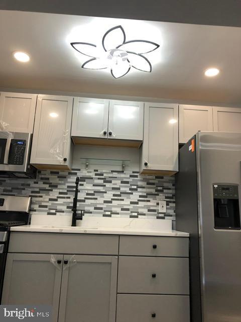 2802 Windsor Avenue Baltimore, MD 21216 - Photo 13 of 37 a kitchen with kitchen island stainless steel appliances a sink cabinets and wooden floor