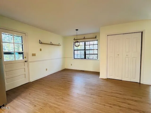 an empty room with wooden floor and cabinet