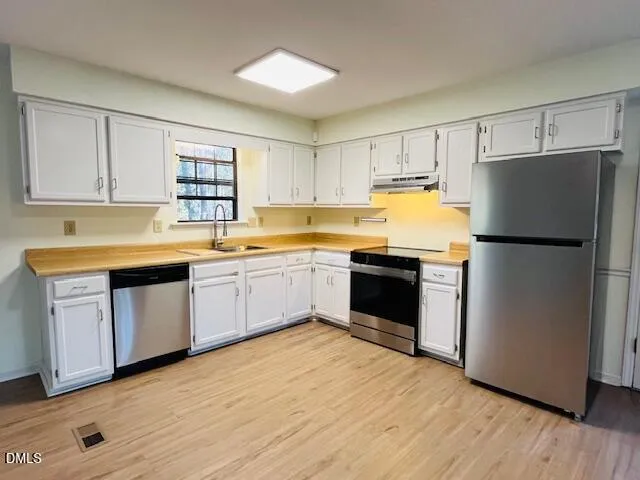 a kitchen with a refrigerator sink and cabinets