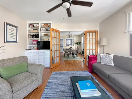 a living room with furniture and a wooden floor