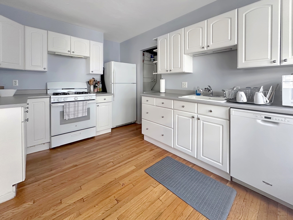 43 Boynton Street, Unit 3R Boston, MA 02130 - Photo 6 of 12 a kitchen with granite countertop white cabinets and white appliances