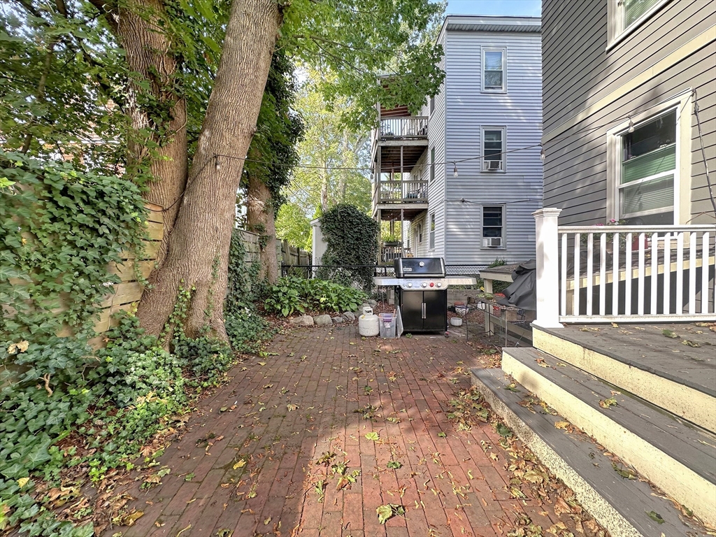 43 Boynton Street, Unit 3R Boston, MA 02130 - Photo 10 of 12 a view of a patio with table and chairs and wooden fence