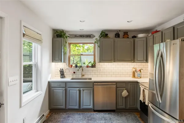 a kitchen with a sink window and refrigerator