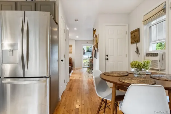 a kitchen with stainless steel appliances a refrigerator a table and chairs