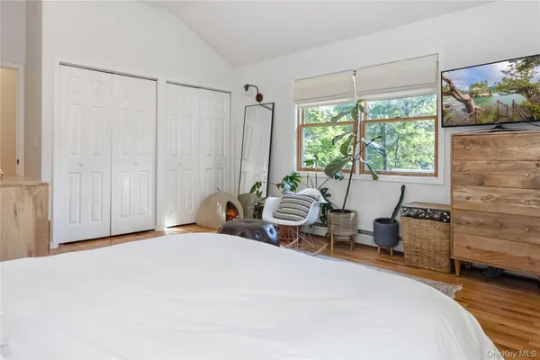 a bedroom with a bed and large windows