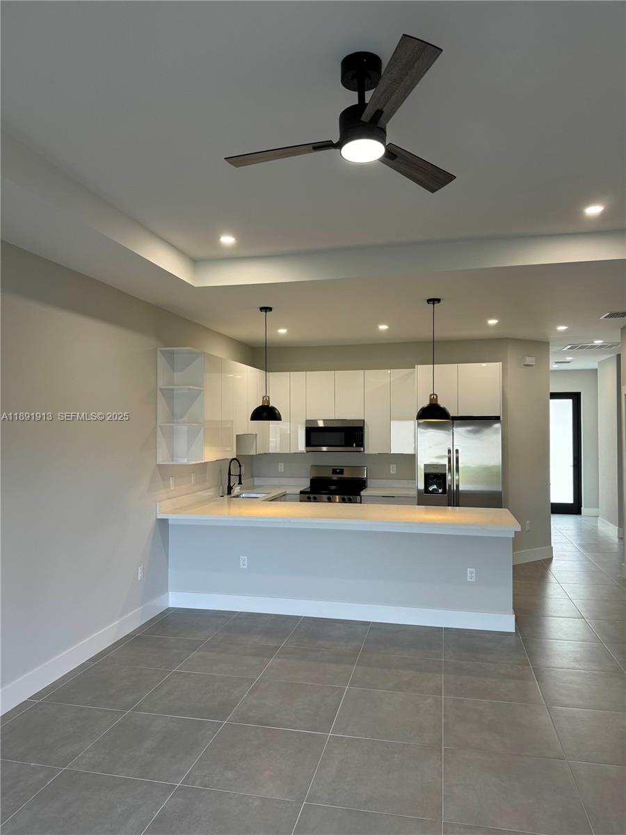 4876-30 30th Street Southwest, Unit 4876 Lehigh Acres, FL 33973 - Photo 2 of 7 a view of kitchen with kitchen island stainless steel appliances sink and microwave