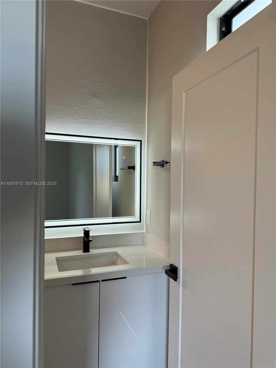 4876-30 30th Street Southwest, Unit 4876 Lehigh Acres, FL 33973 - Photo 5 of 7 a bathroom with a sink and mirror