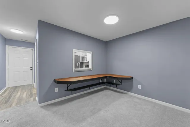 a view of an empty room with a fireplace and a window