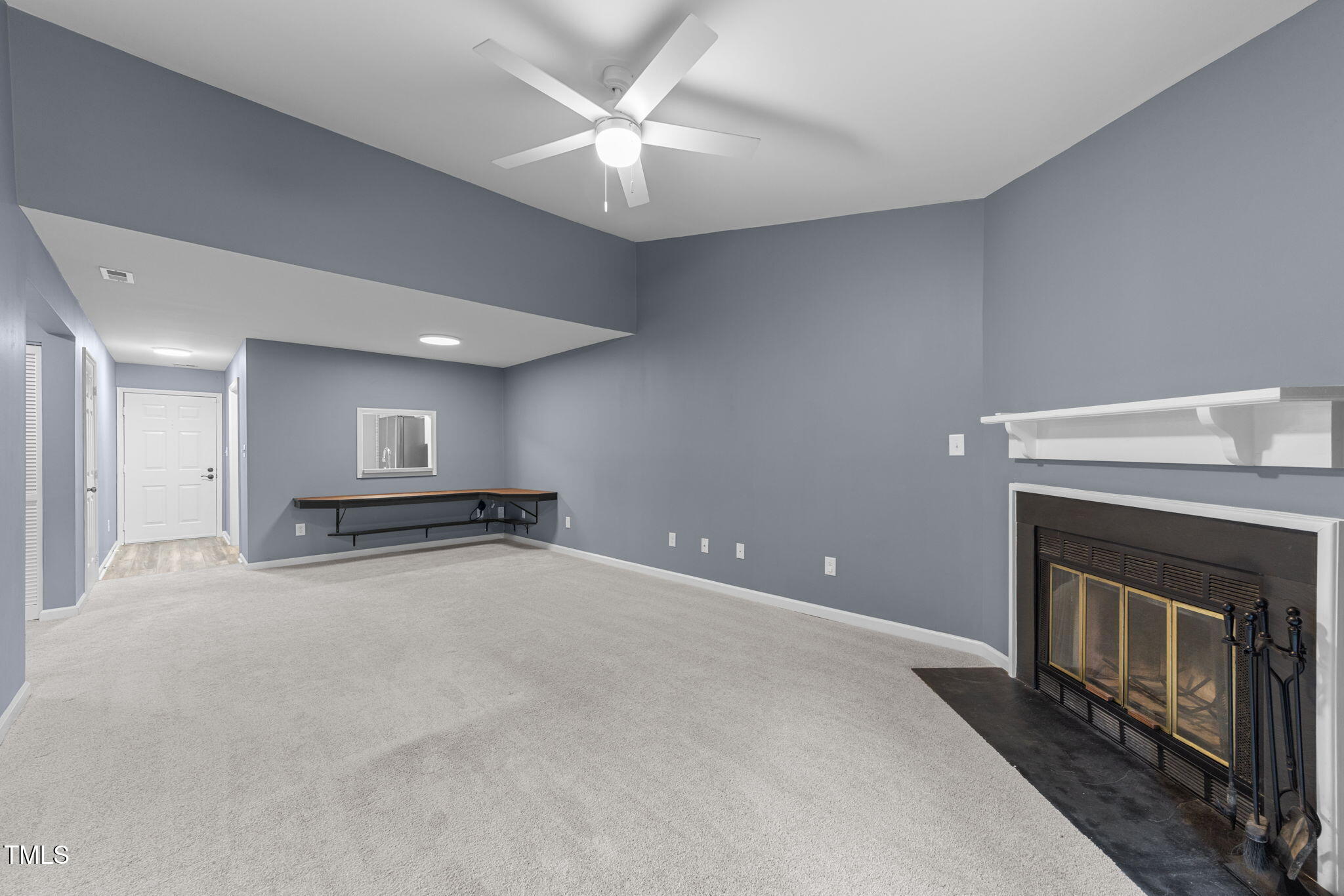 4601 Timbermill Court, Unit 303 Raleigh, NC 27612 - Photo 12 of 37 a view of an empty room with chandelier fan and fire place