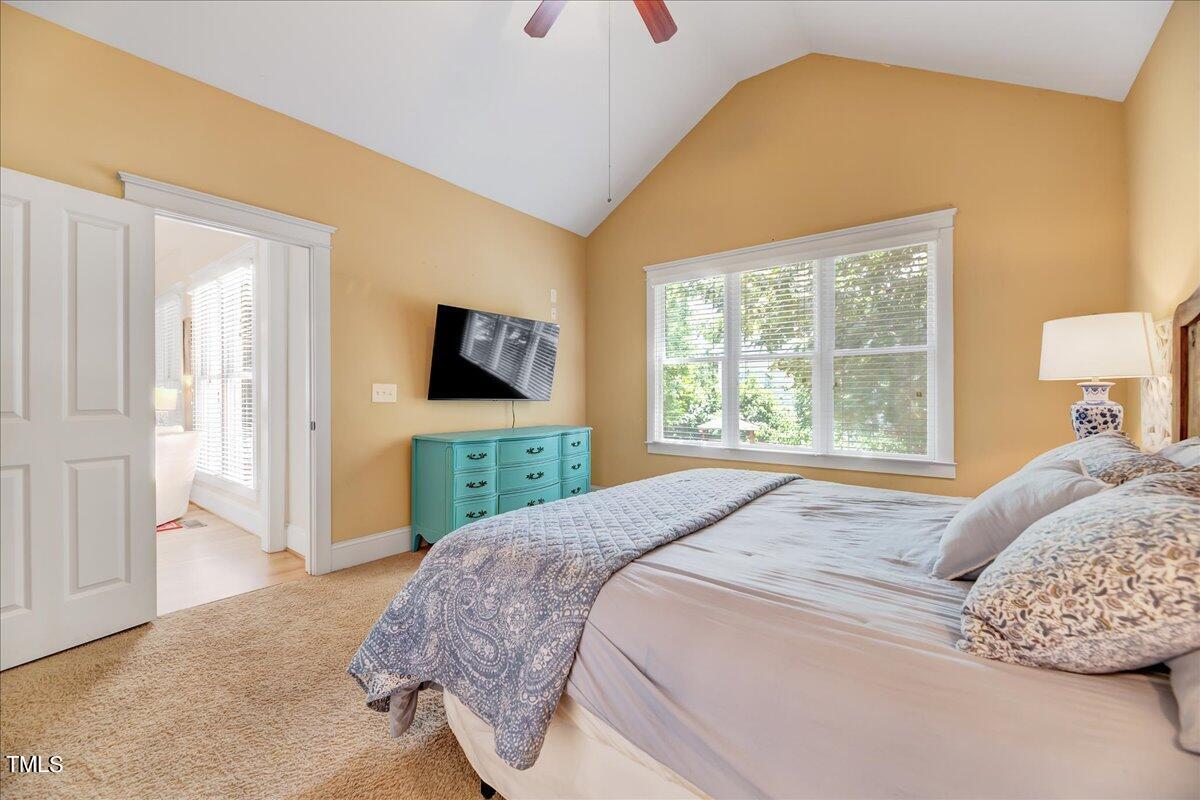 2901 Brighton Bluff Drive Apex, NC 27539 - Photo 16 of 35 a bedroom with a bed and a flat tv screen next to a window