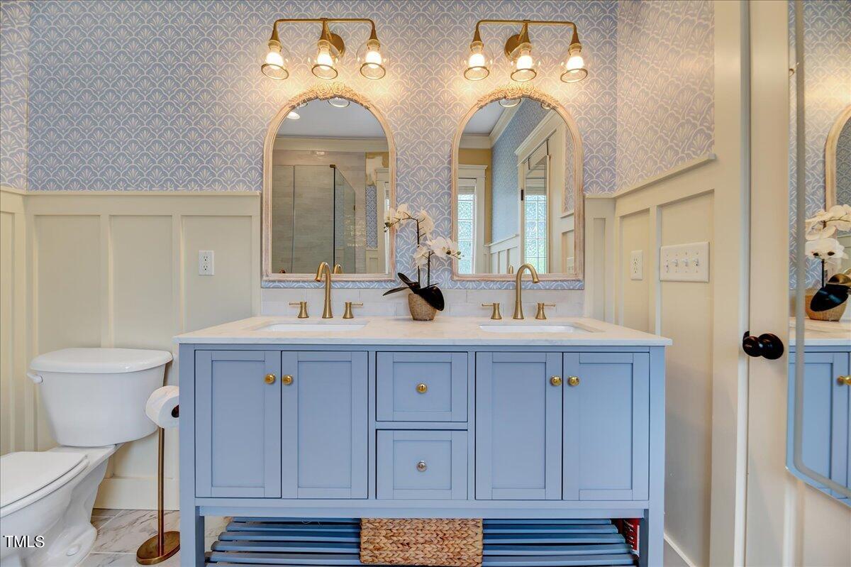 2901 Brighton Bluff Drive Apex, NC 27539 - Photo 17 of 35 a bathroom with a double vanity sink a toilet and a mirror