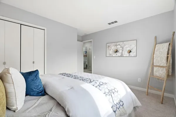 a bedroom with a large bed and a chandelier