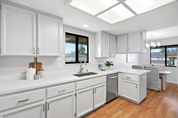 a kitchen with white cabinets white appliances and sink