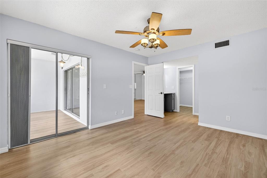 5197 Silent Loop, Unit 124 New Port Richey, FL 34652 - Photo 32 of 55 an empty room with wooden floor chandelier fan and windows