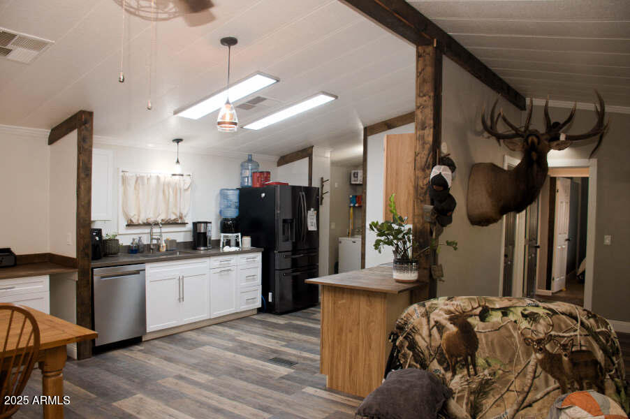 200 North Tomahawk Road Apache Junction, AZ 85119 - Photo 11 of 56 a kitchen with stainless steel appliances kitchen island granite countertop a refrigerator a sink dishwasher a stove and white cabinets with wooden floor