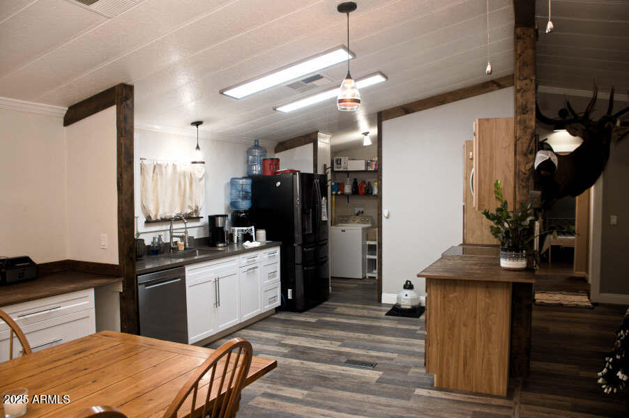 200 North Tomahawk Road Apache Junction, AZ 85119 - Photo 18 of 56 a kitchen with stainless steel appliances kitchen island granite countertop a refrigerator a stove and a sink with wooden floor