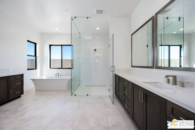 a spacious bathroom with a tub sink shower and mirror