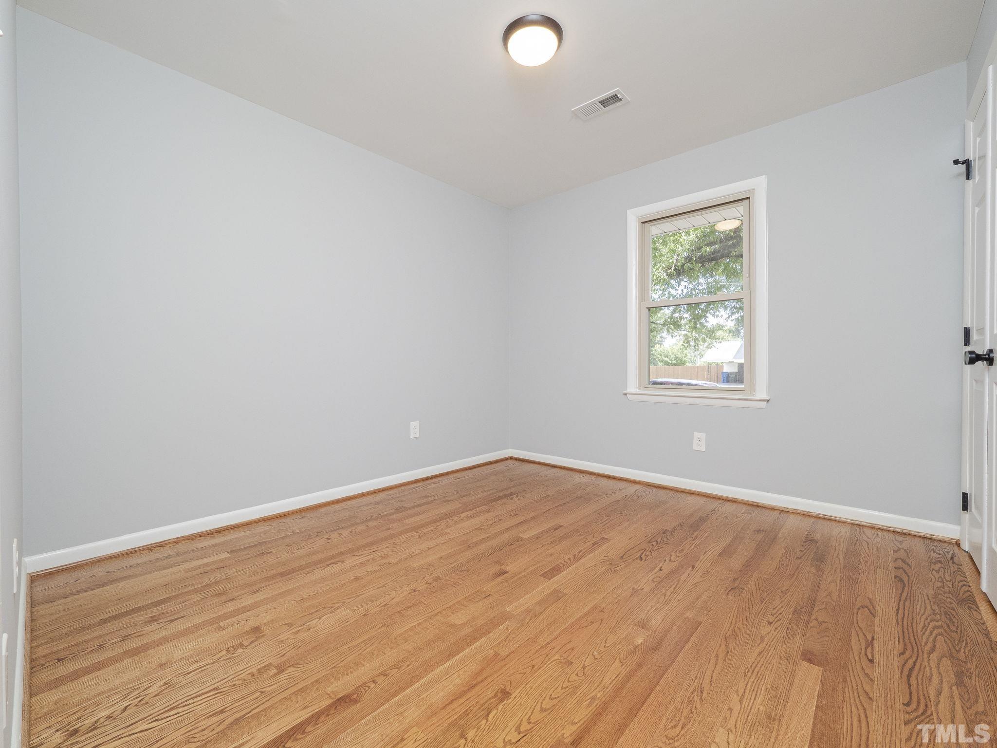5309 Knollwood Road Raleigh, NC 27609 - Photo 12 of 19 an empty room with wooden floor and windows