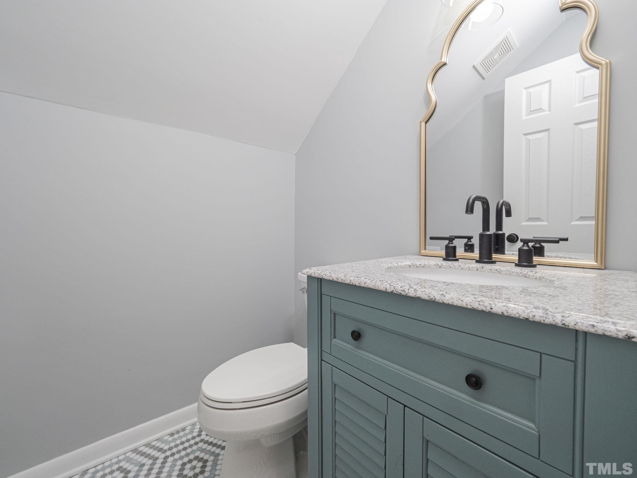 5309 Knollwood Road Raleigh, NC 27609 - Photo 16 of 19 a bathroom with a granite countertop toilet sink and mirror