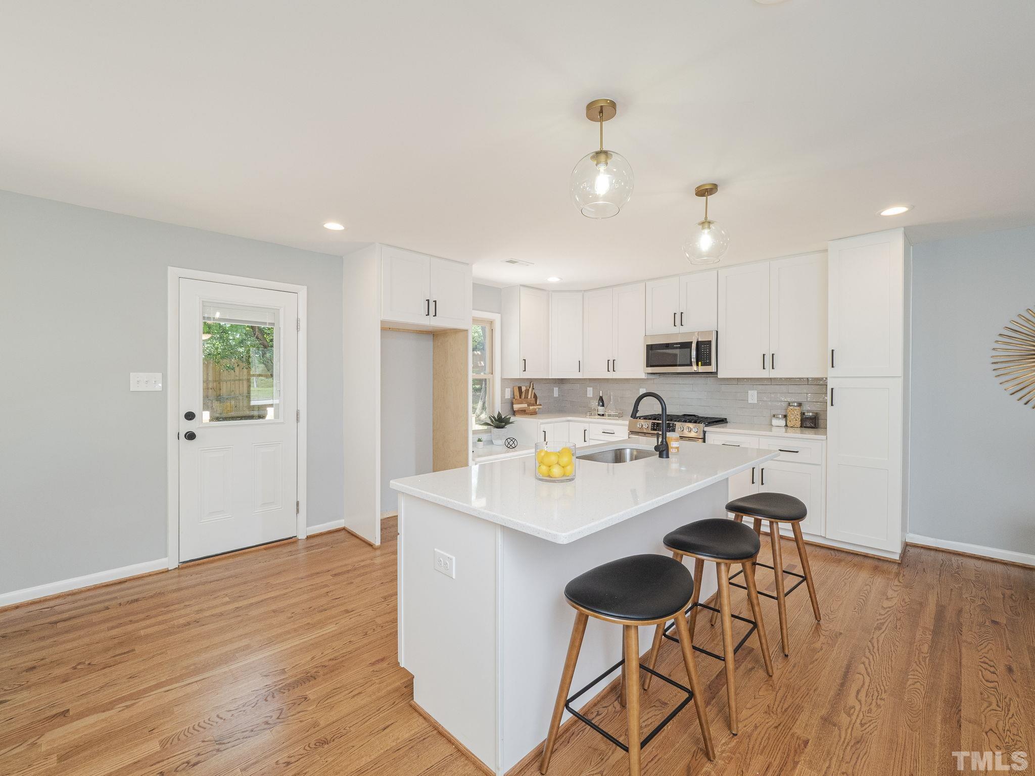 5309 Knollwood Road Raleigh, NC 27609 - Photo 6 of 19 a view of a kitchen with kitchen island white cabinets and stainless steel appliances