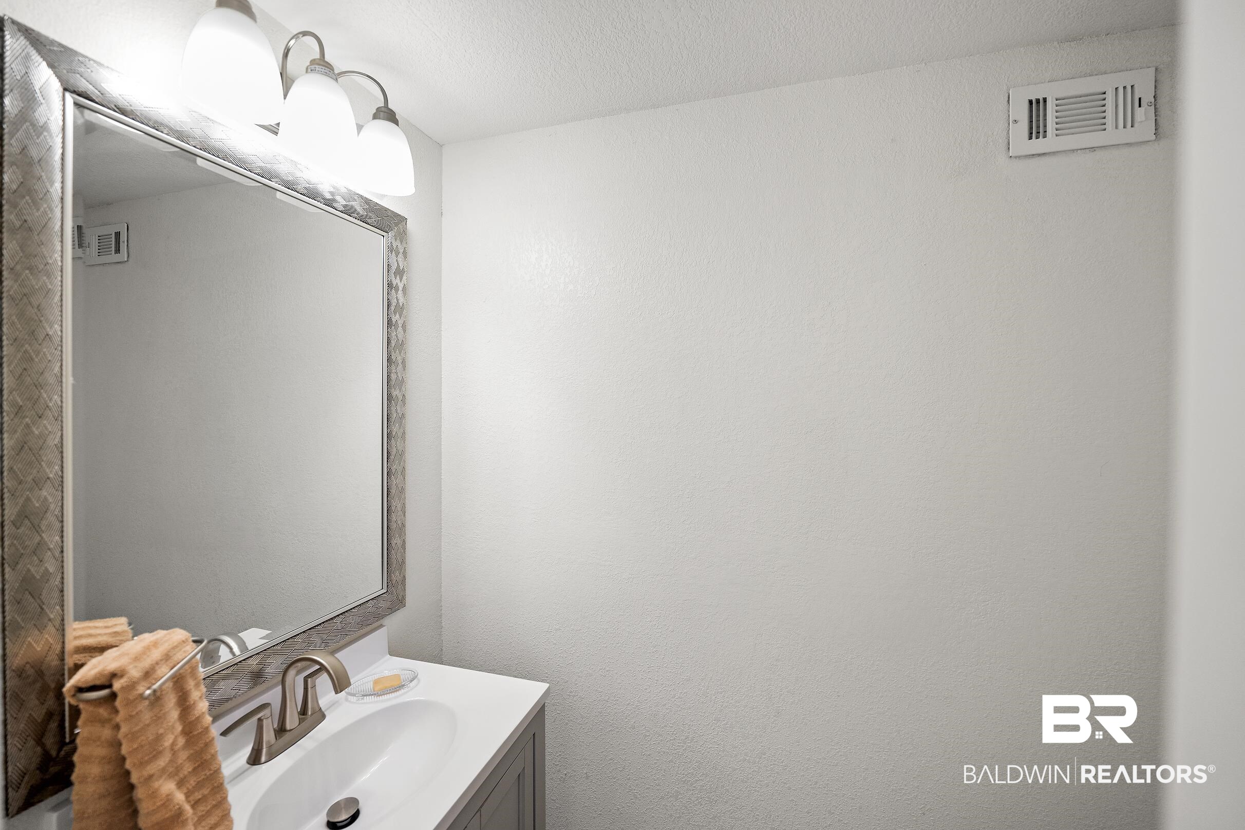 33129 Antietam Road Lillian, AL 36549 - Photo 22 of 31 Bathroom vanity featuring a rectangular undermount sink, brushed nickel faucet, and a white countertop