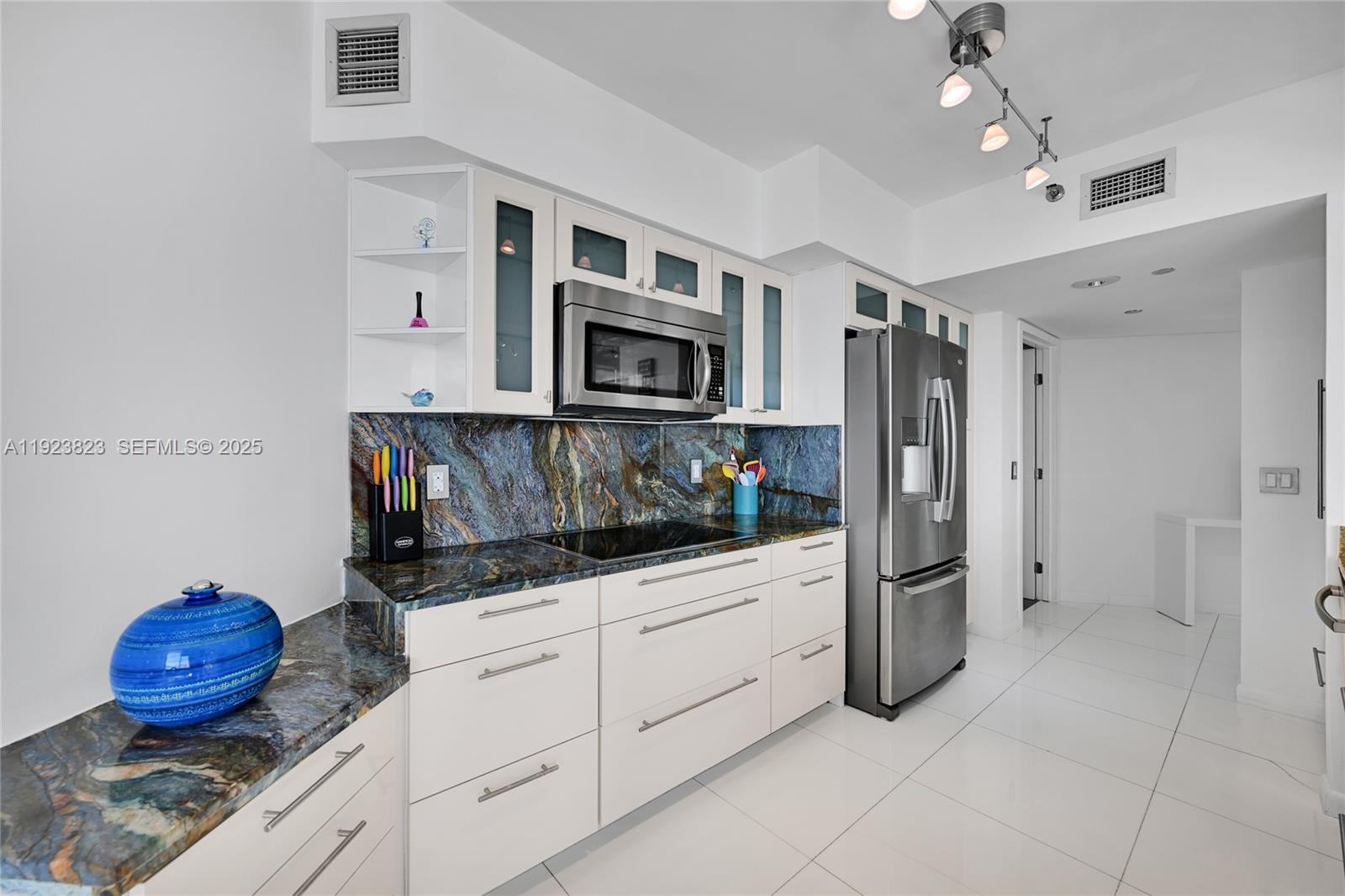 16445 Collins Avenue, Unit 2228 Sunny Isles Beach, FL 33160 - Photo 11 of 36 a kitchen with stainless steel appliances granite countertop a refrigerator sink and microwave
