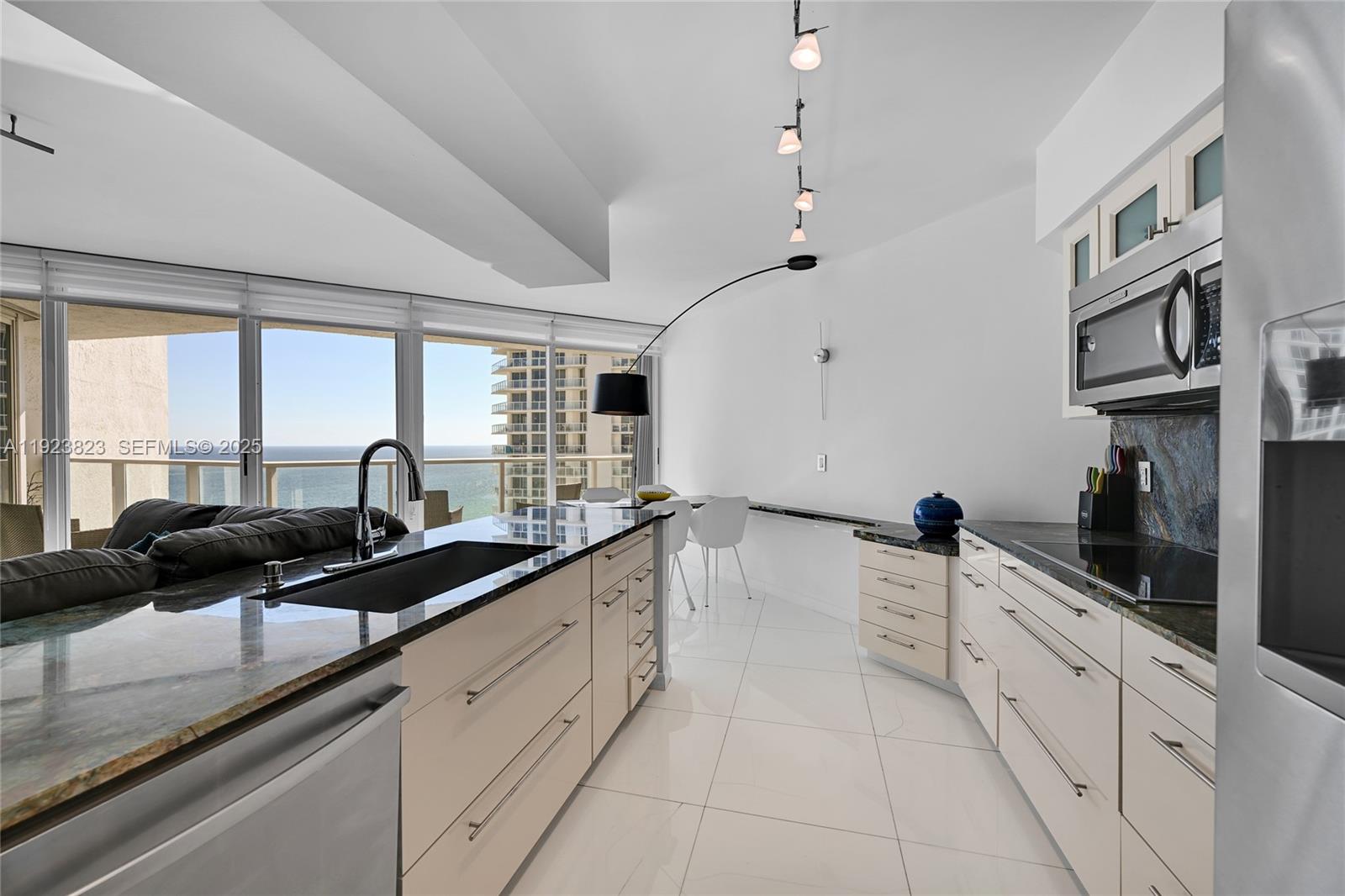 16445 Collins Avenue, Unit 2228 Sunny Isles Beach, FL 33160 - Photo 13 of 36 a large white kitchen with a sink and cabinets