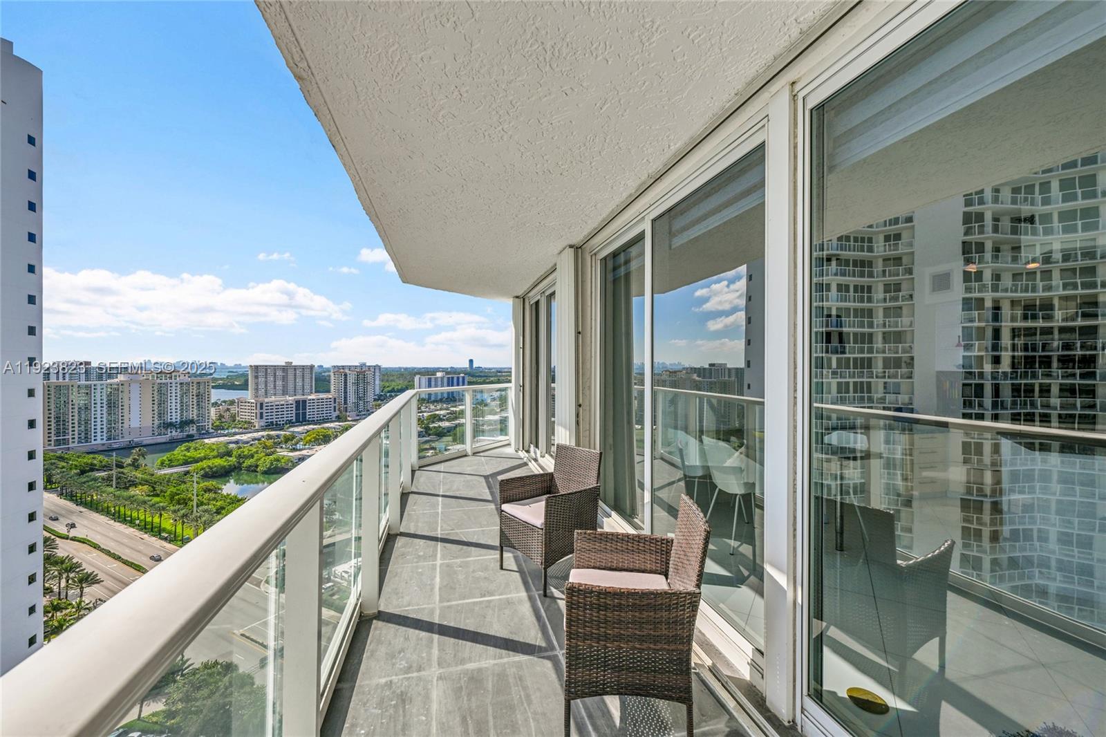 16445 Collins Avenue, Unit 2228 Sunny Isles Beach, FL 33160 - Photo 16 of 36 a balcony with wooden floor and outdoor seating