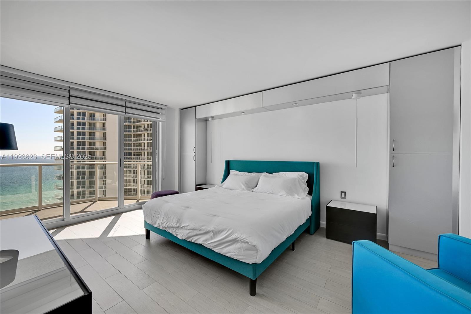 16445 Collins Avenue, Unit 2228 Sunny Isles Beach, FL 33160 - Photo 18 of 36 a bedroom with a bed window and wooden floor