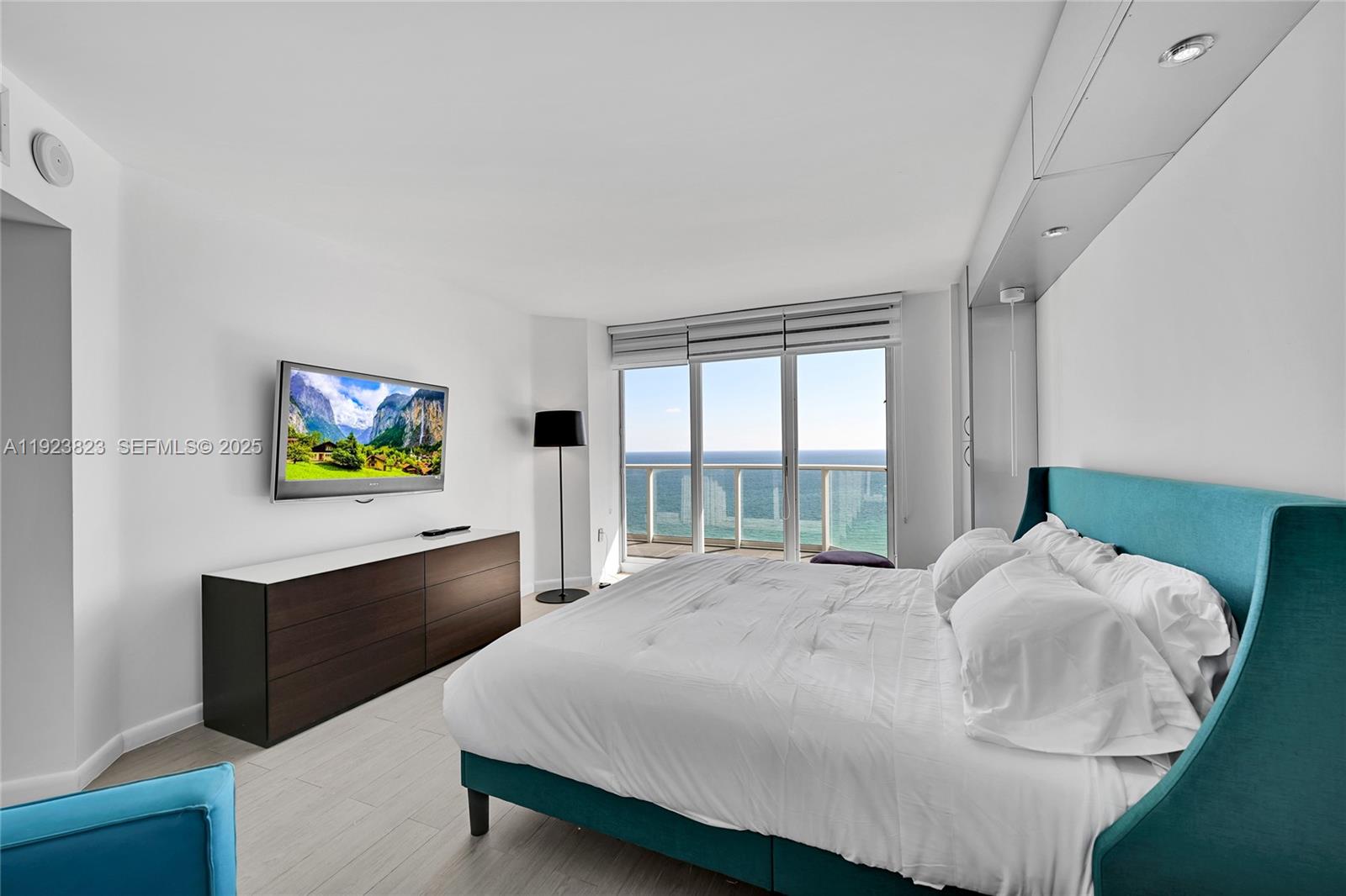 16445 Collins Avenue, Unit 2228 Sunny Isles Beach, FL 33160 - Photo 19 of 36 a bedroom with a bed and a flat screen tv