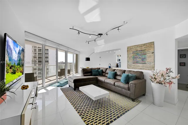 a living room with furniture large window and flat screen tv