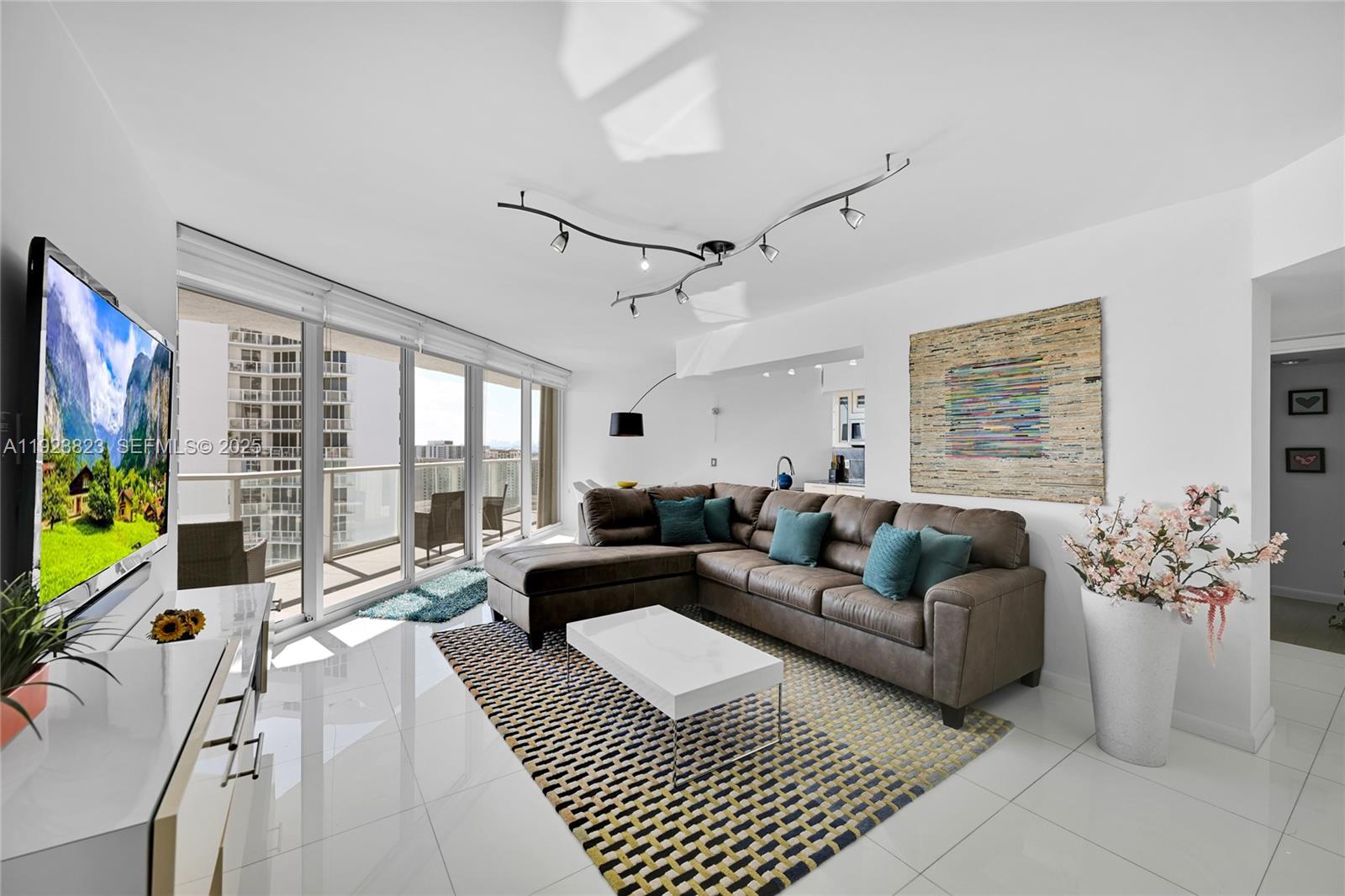 16445 Collins Avenue, Unit 2228 Sunny Isles Beach, FL 33160 - Photo 2 of 36 a living room with furniture large window and flat screen tv