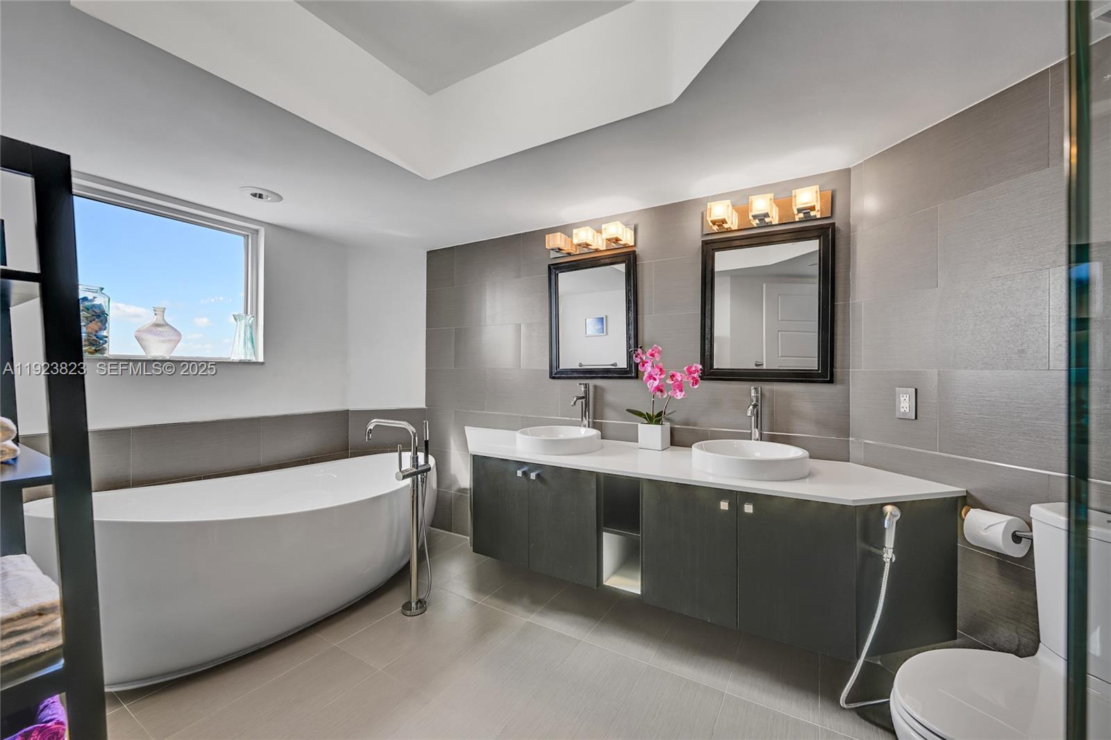 16445 Collins Avenue, Unit 2228 Sunny Isles Beach, FL 33160 - Photo 22 of 36 a bathroom with a tub double vanity sink and mirror