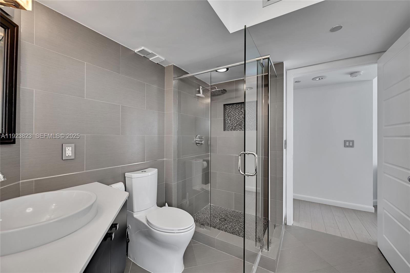 16445 Collins Avenue, Unit 2228 Sunny Isles Beach, FL 33160 - Photo 24 of 36 a bathroom with a toilet a sink and shower