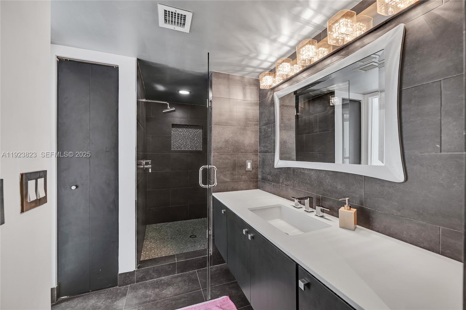 16445 Collins Avenue, Unit 2228 Sunny Isles Beach, FL 33160 - Photo 36 of 36 a bathroom with a sink shower and a mirror