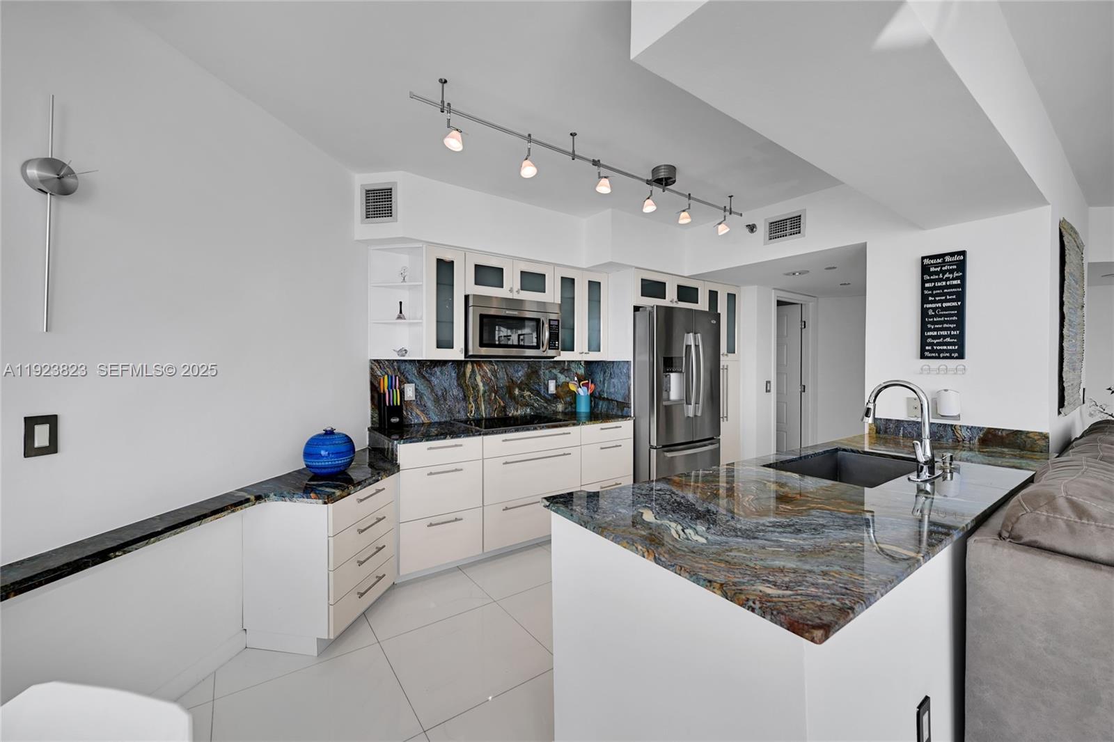 16445 Collins Avenue, Unit 2228 Sunny Isles Beach, FL 33160 - Photo 7 of 36 a kitchen with stainless steel appliances granite countertop a sink refrigerator and cabinets