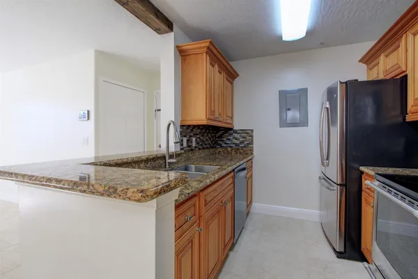 a kitchen with granite countertop a sink stove and refrigerator
