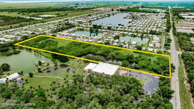 an aerial view of a house with a garden and lake view